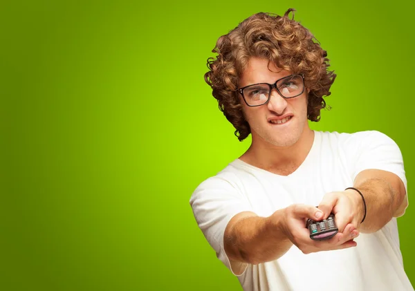 Portrait Of Young Man With Glasses Changing Channel With Tv Cont — Stock Photo, Image