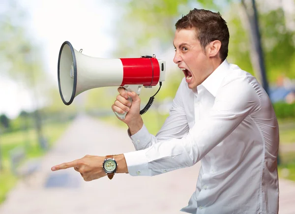 Portret van jonge man schreeuwen op megafoon — Stockfoto
