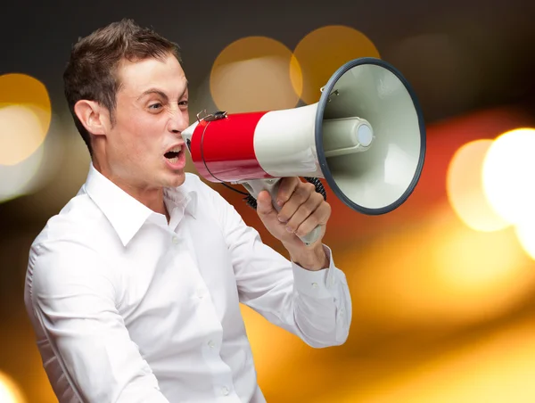 Portret van jonge man schreeuwen op megafoon — Stockfoto
