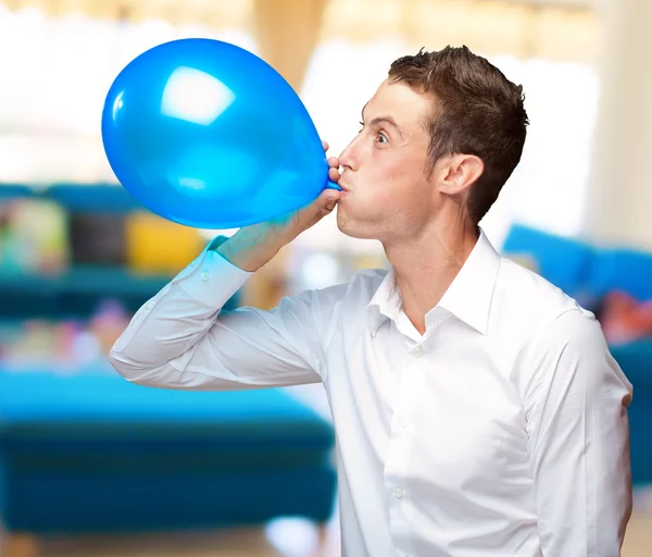 Portrait Of Young Man Blowing A Balloon — Stock Photo, Image