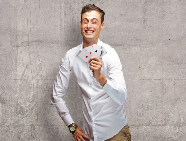 Poker kartları tutan genç adam portresi — Stok fotoğraf