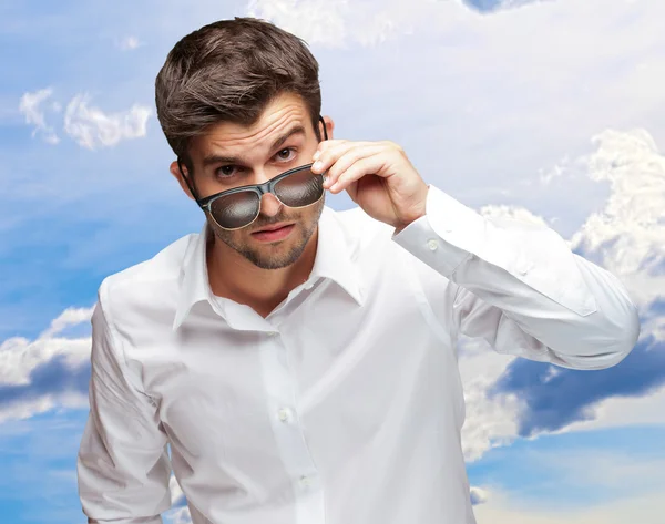 Retrato de jovem dando olhar enquanto segurando óculos — Fotografia de Stock
