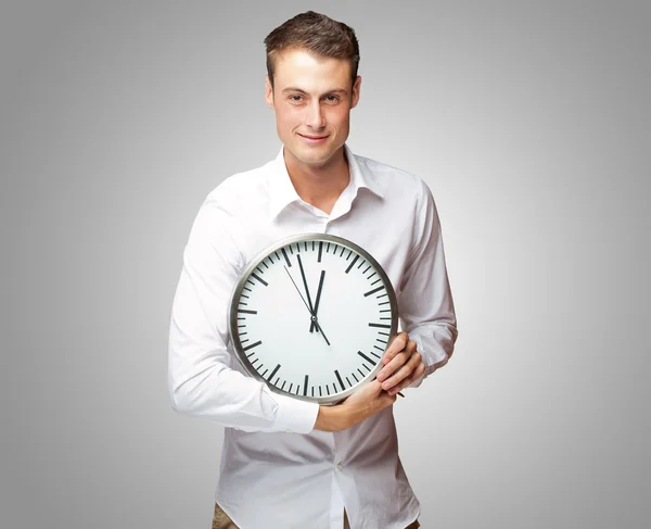 Homem feliz segurando relógio em sua mão — Fotografia de Stock