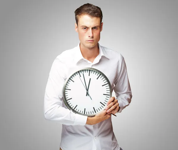 Podobizna mladého muže drží hodiny — Stock fotografie
