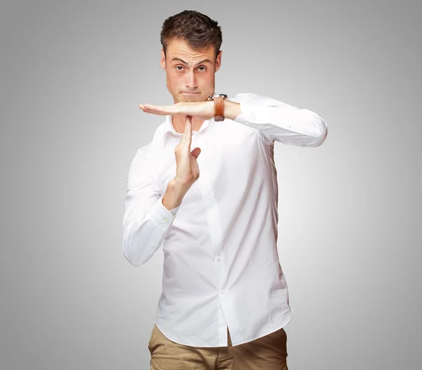 Portret młodego mężczyzny gestykulującego czas poza znakiem — Zdjęcie stockowe
