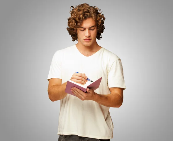 Um jovem escrevendo em um caderno — Fotografia de Stock