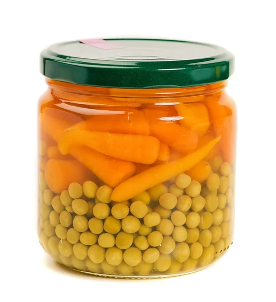Färska morötter och gröna ärtor i en glasburk — Stockfoto