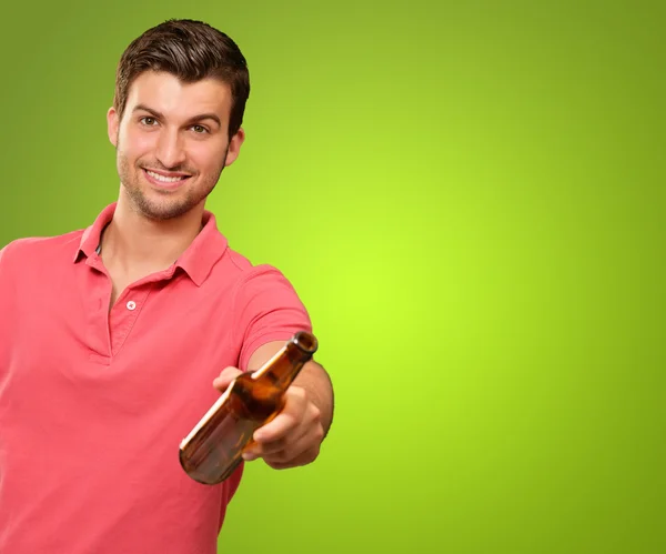 Young man holding a beer — Stock Photo, Image