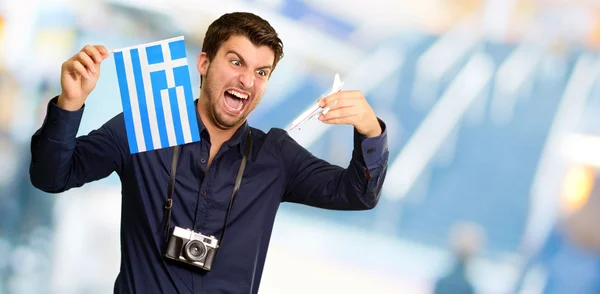Man holding flag and miniature airplane — Stock Photo, Image