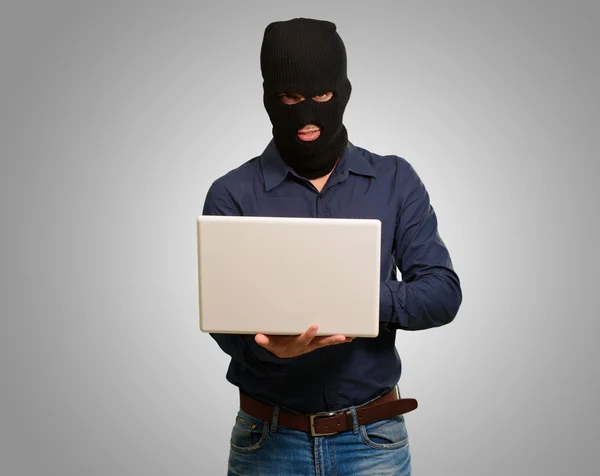 Giovane ladro maschio in possesso di laptop — Foto Stock