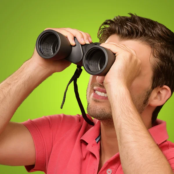 Příležitostné muž hledá do binokulární — Stock fotografie