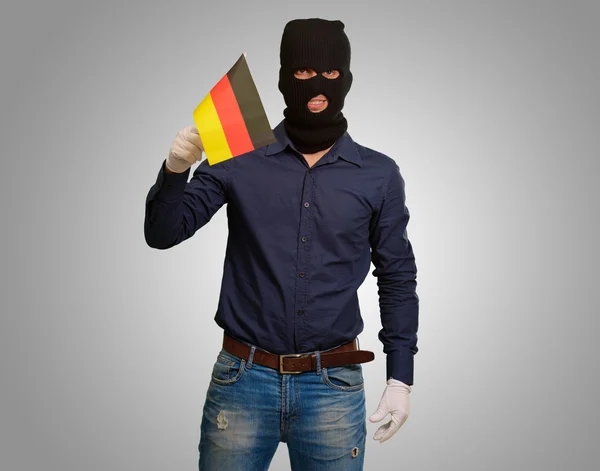 Homem usando máscara de ladrão e segurando bandeira — Fotografia de Stock