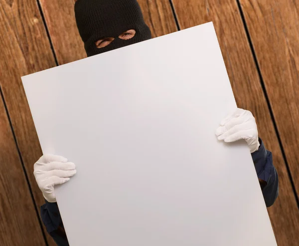 Retrato de un hombre con máscara sosteniendo la tarjeta en blanco —  Fotos de Stock