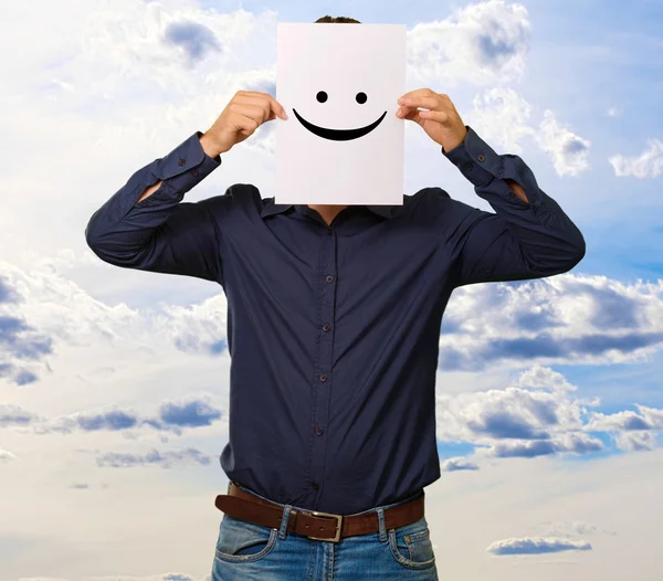 Man holding a card with face paper — Stock Photo, Image