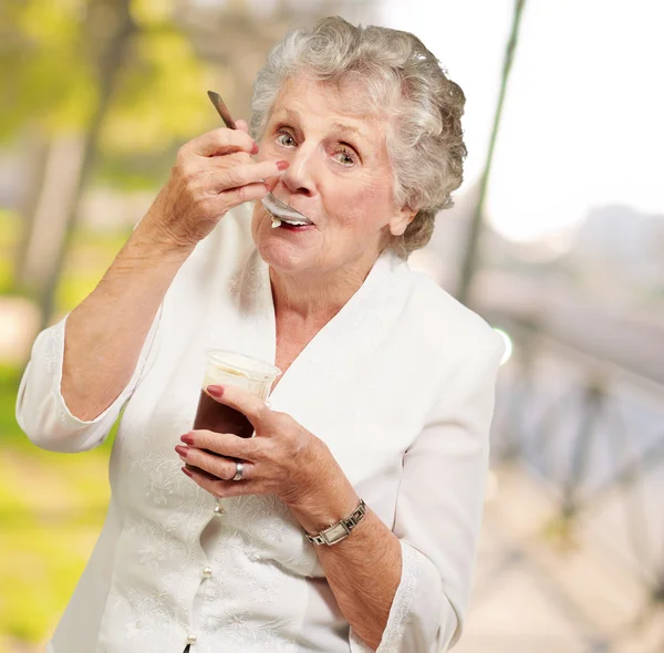 Зрелая женщина стоит и пьет здоровый напиток — стоковое фото