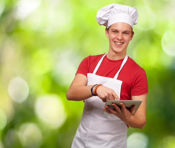 Jeune cuisinier tenant une tablette numérique — Photo