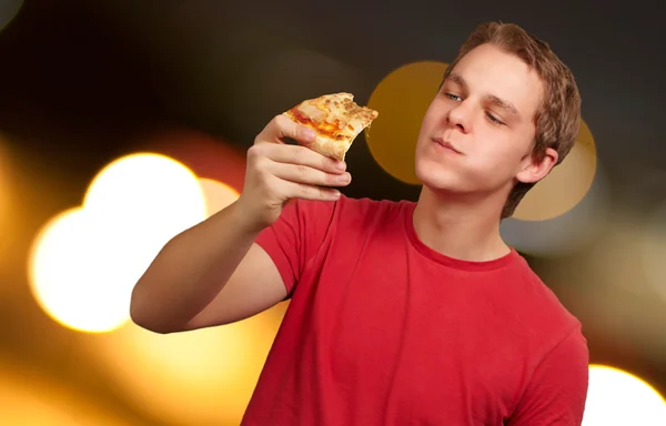 Πορτρέτο του ένα νεαρό άνδρα που τρώει πίτσα — Φωτογραφία Αρχείου