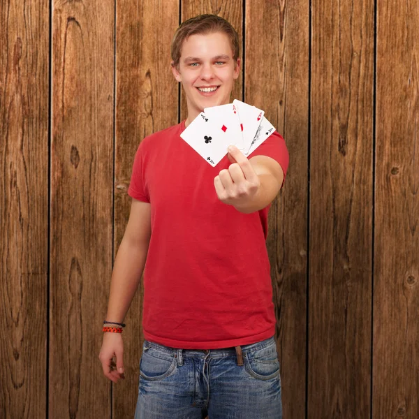 Portrét mladého muže drží čtyři esa — Stockfoto