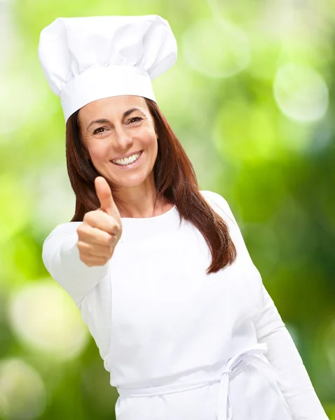 Женщина-повар показывает большие пальцы вверх — стоковое фото
