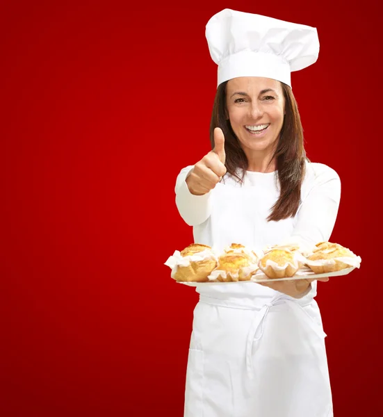 Kobieta kucharz trzyma jedzenie pieczone — Zdjęcie stockowe