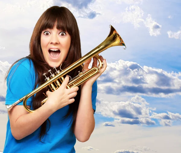 Mujer sorprendida sosteniendo trompeta — Foto de Stock