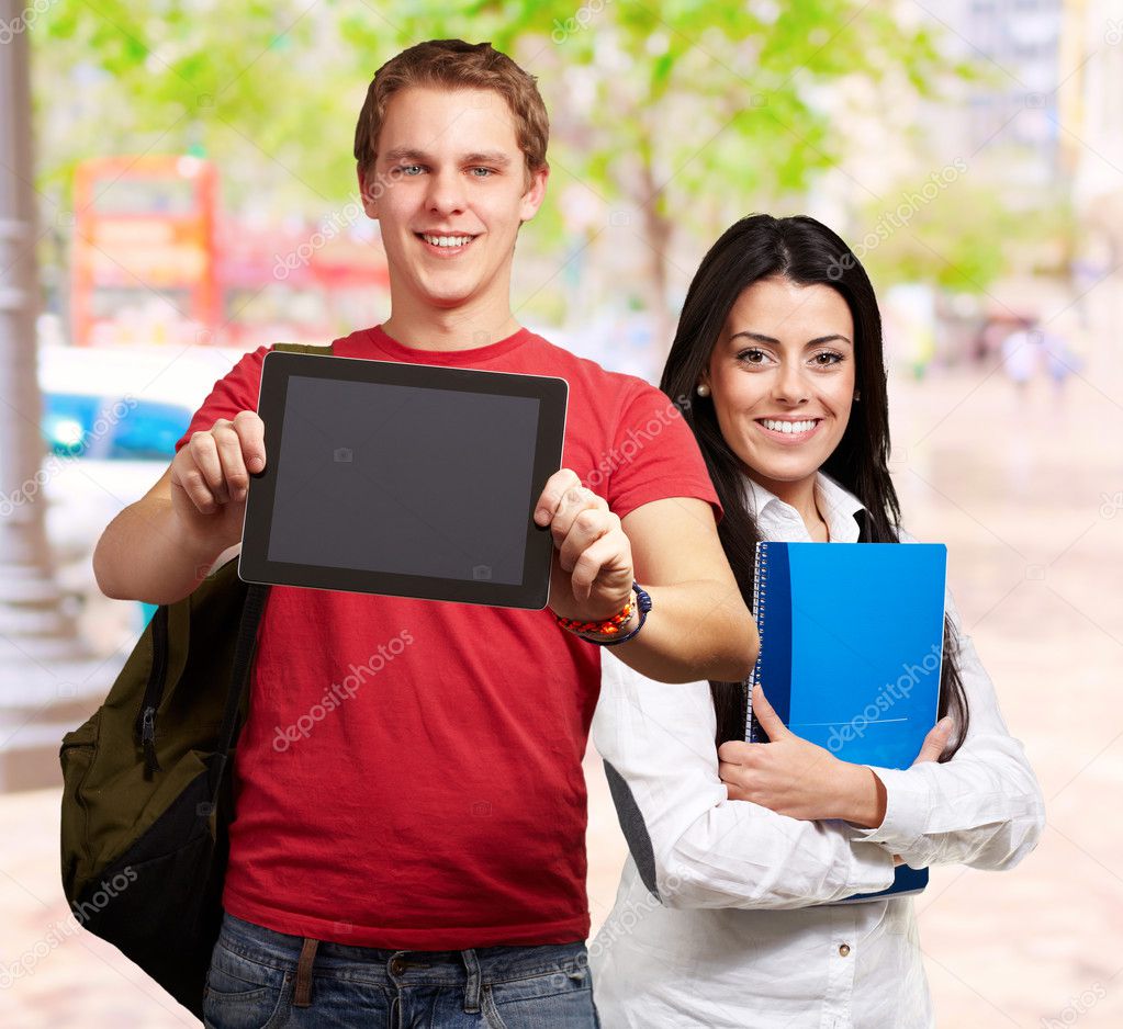 Students holding tablet and books