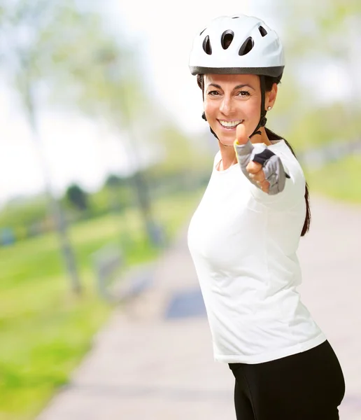 Mulher usando capacete mostrando polegar para cima — Fotografia de Stock