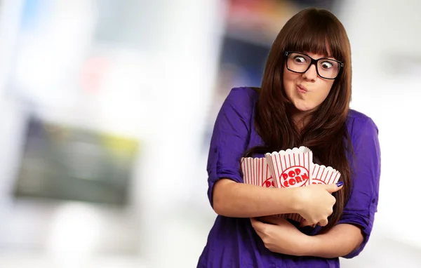 Portret młodej kobiety trzymając pojemnik popcorn — Zdjęcie stockowe