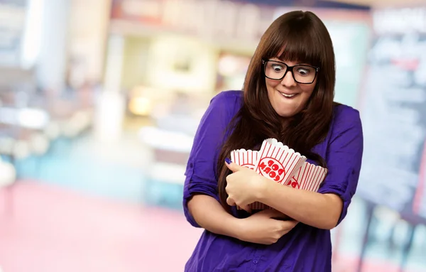 Portret van een jonge vrouw met popcorn container — Stockfoto