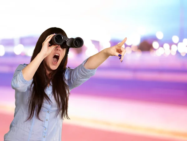 Retrato de uma jovem mulher olhando através de binóculos — Fotografia de Stock