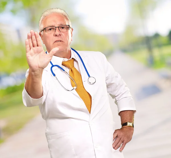 Retrato de un médico varón mostrando señal de advertencia — Foto de Stock