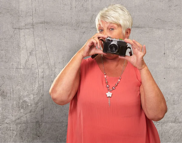 Donna anziana che tiene macchina fotografica — Foto Stock