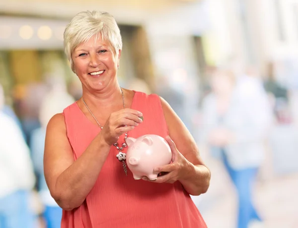 Senior vrouw met een spaarpot — Stockfoto