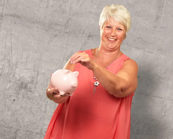 Senior vrouw met een spaarpot — Stockfoto