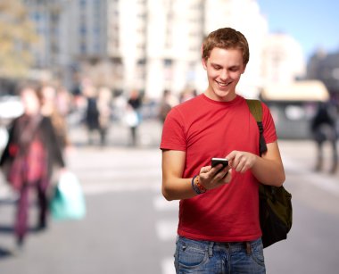 genç adam, kalabalık cadde mobil ekran dokunaklı portresi