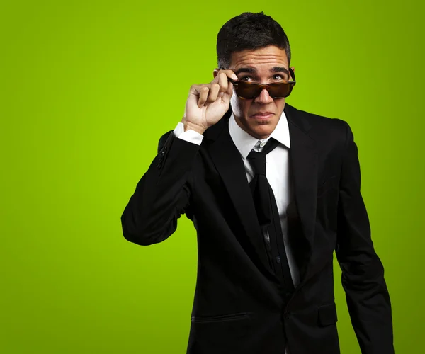 Портрет ділового чоловіка, що знімає сонцезахисні окуляри на тлі сірого — стокове фото