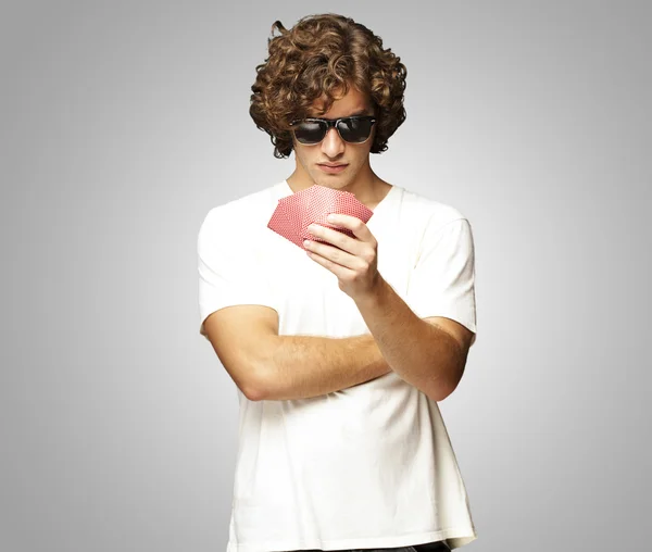 Ritratto di giovane uomo che indossa occhiali da sole e gioca a poker — Foto Stock