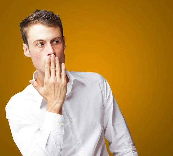 Portret van een jonge man die betrekking hebben op zijn mond met de hand — Stockfoto