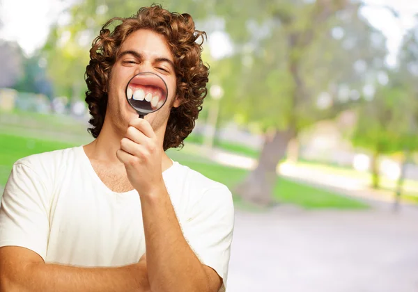 Homem examinando seus dentes com lupa — Fotografia de Stock