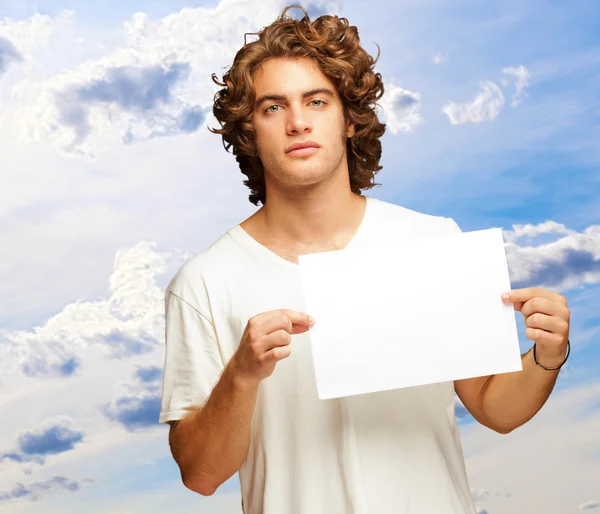 Jovem homem casual segurando uma mensagem em branco — Fotografia de Stock
