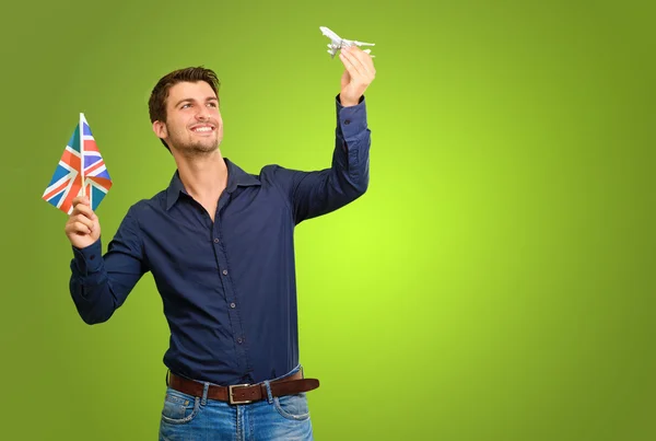 Man holding flag and miniature of airplane — Stock Photo, Image