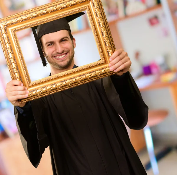 Homme diplômé regardant à travers un cadre — Photo