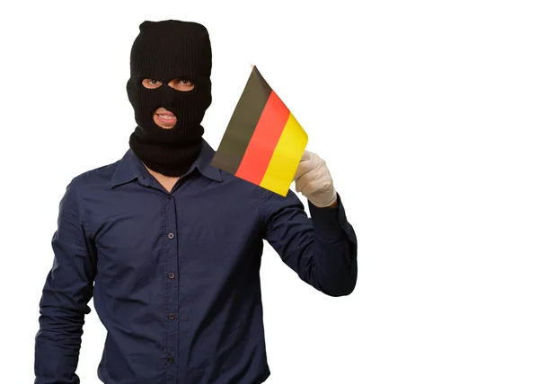 Άνθρωπος φορώντας μάσκα ληστής και κρατώντας την σημαία — Φωτογραφία Αρχείου