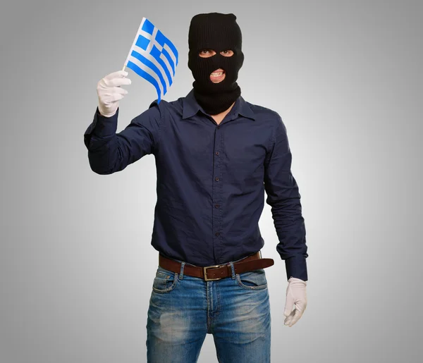 Man bär rånare mask och hålla flaggan — Stockfoto