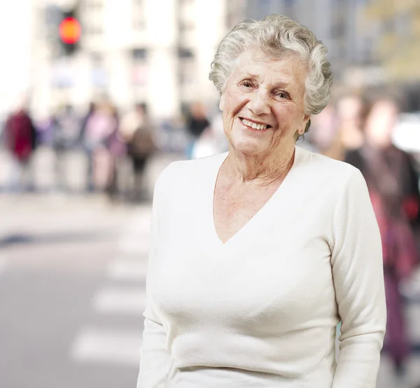 Bella donna anziana sorridente su uno sfondo stradale — Foto Stock