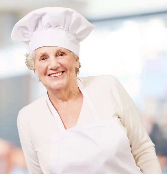 Portret kobiety starszy kucharz, uśmiechający się wnętrze — Zdjęcie stockowe
