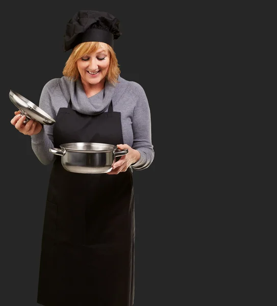 Retrato de uma mulher enquanto cozinha alimentos — Fotografia de Stock