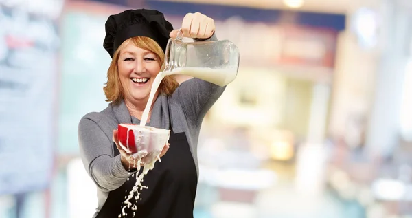 Retrato de una mujer que vierte leche — Foto de Stock