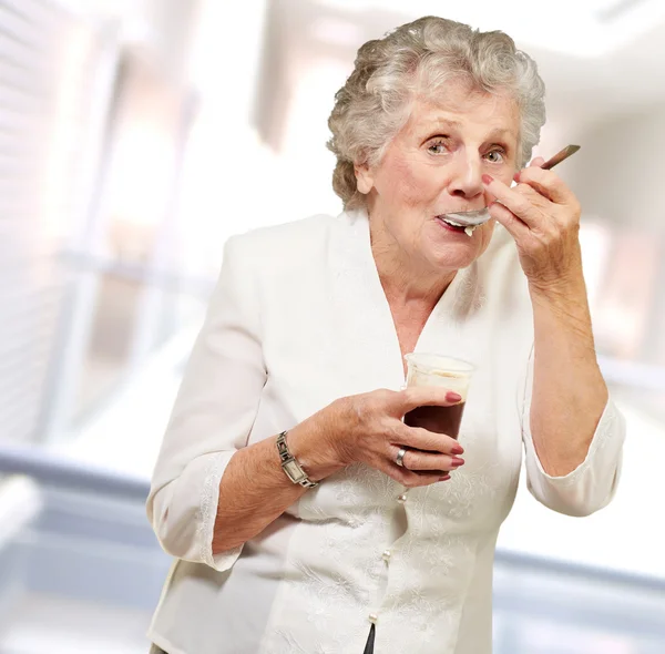 Starsza kobieta stojąc i biorąc zdrowy napój — Zdjęcie stockowe