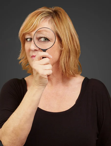 Woman using a magnifying glass — Stock Photo, Image